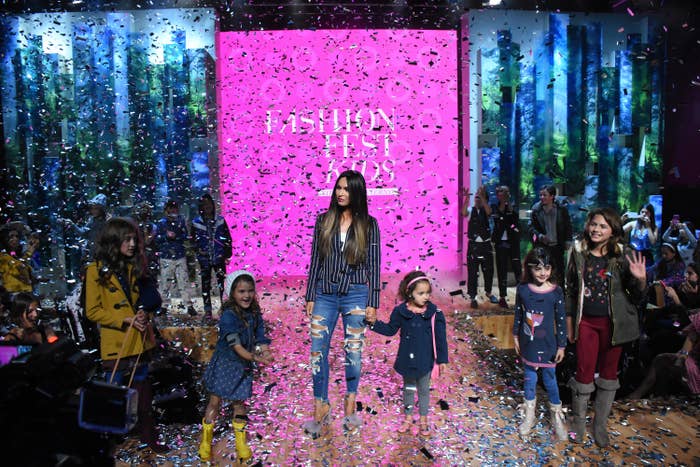 Megan standing on a catwalk with her kids as confetti rains down