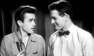 Black-and-white GIF of James Dean and Paul Newman laughing