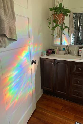 a reviewer photo of a rainbow shining onto a white door 