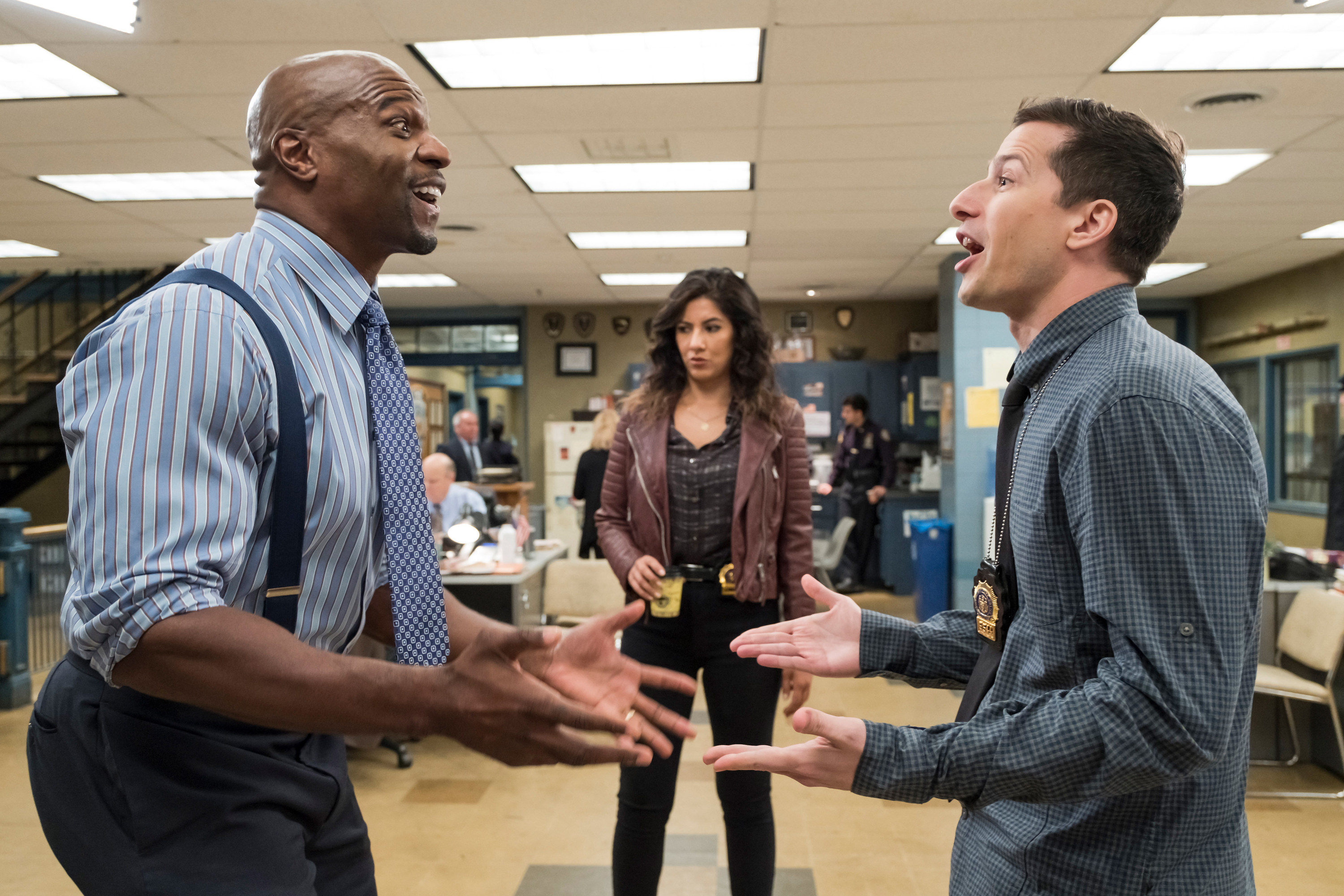Terry Crews and Andy Samberg argue with Stephanie Beatriz in the background