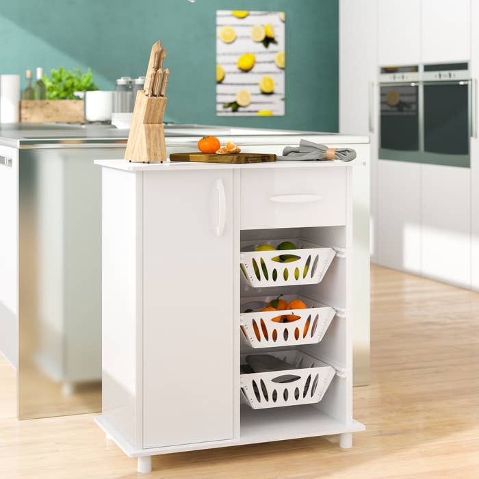 White storage cabinet with three baskets, storage cabinet and microwave on top
