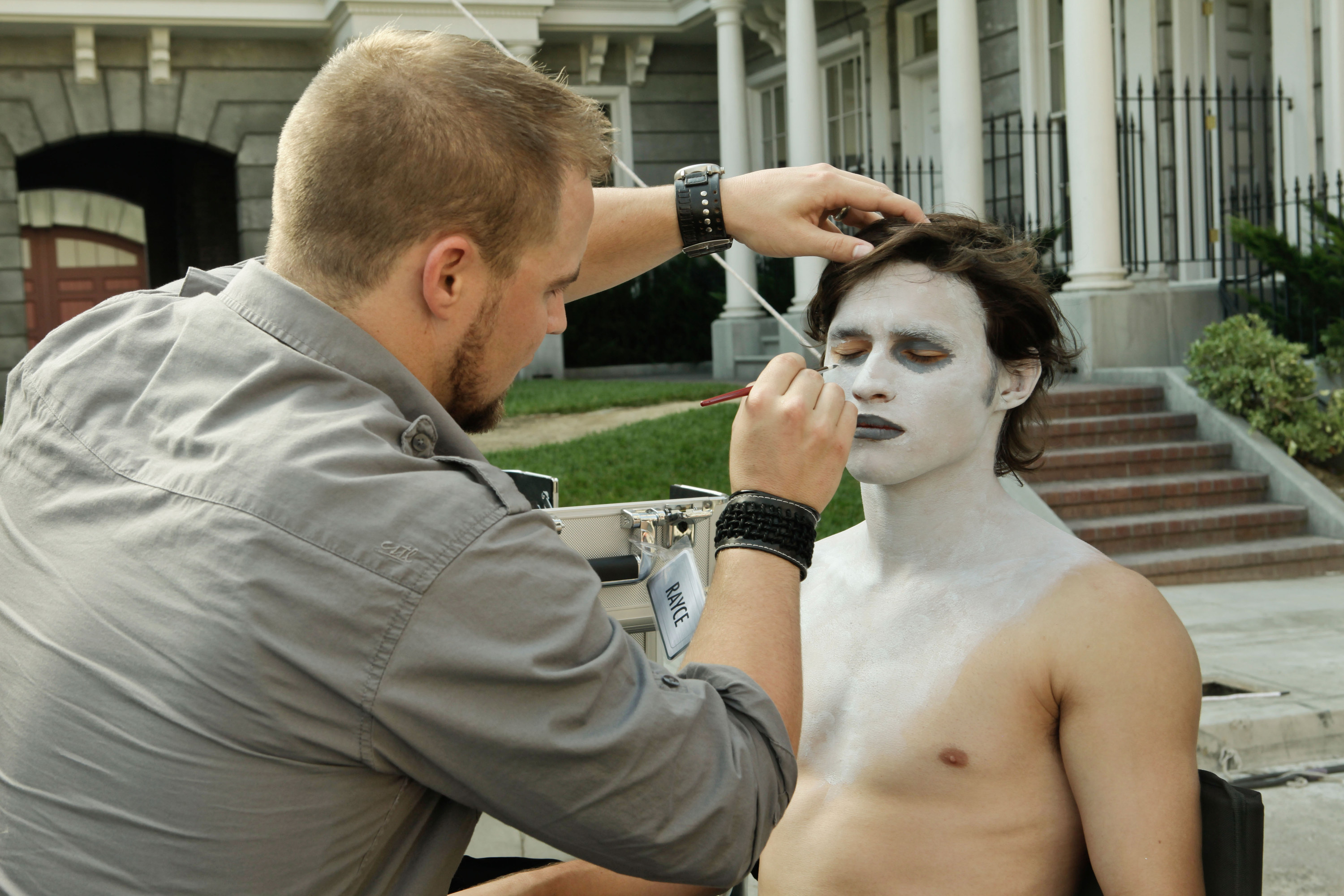 Rayce Bird does makeup on a man