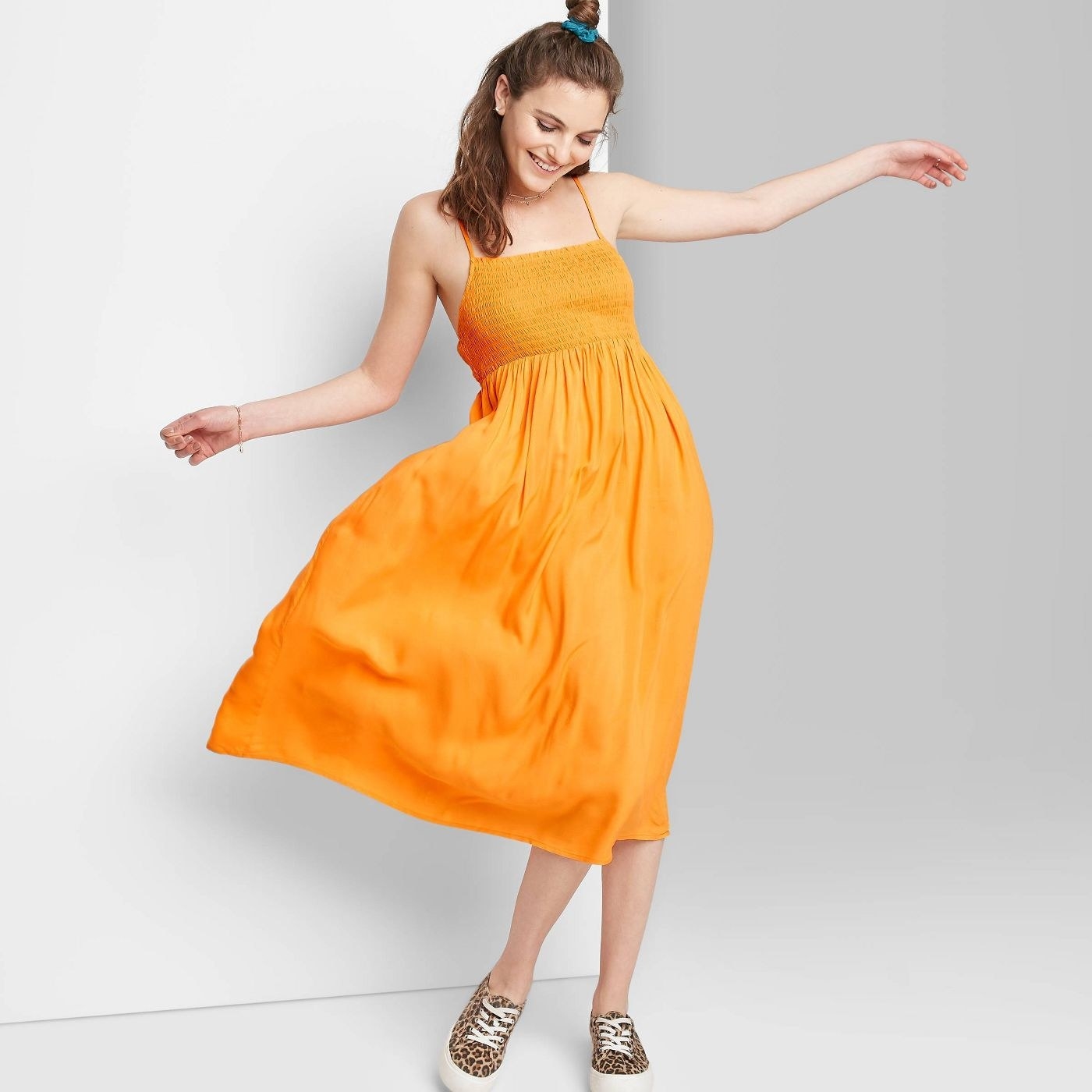 A model wearing a yellow sleeveless smocked dress