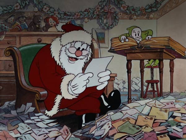 Santa Claus sits among a pile of letters