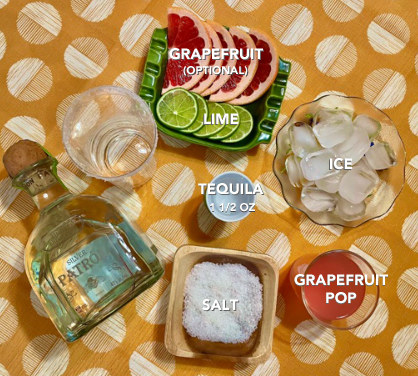 a bottle of silver patron, salt-rimmed glass, salt, tequila shot, ice, grapefruit soda, slices of grapefruit and lime