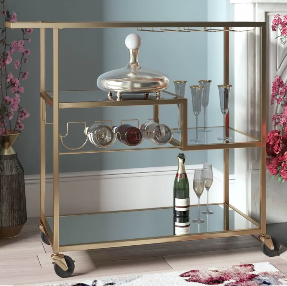 Gold bar cart with with wine rack, glasses and wine on cart