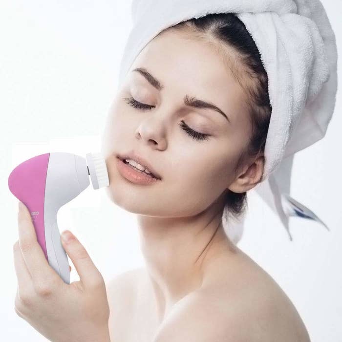 A woman using the facial cleansing brush.