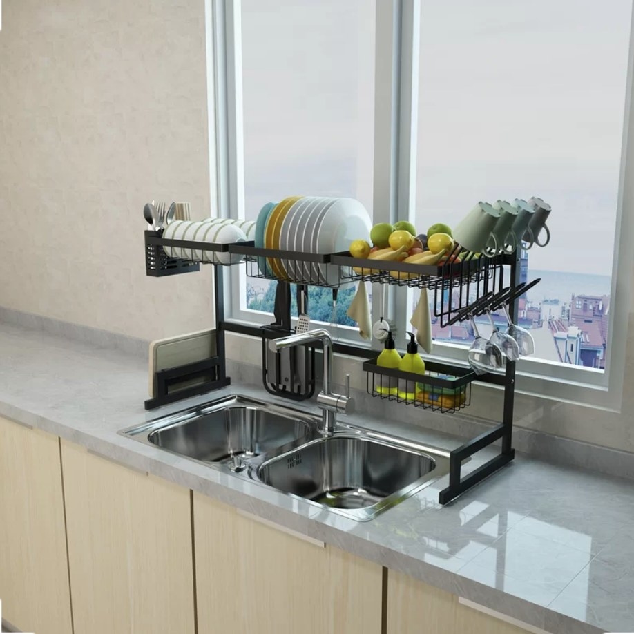 Black rack over the sink with fruits store, cups stacked, and plates drying