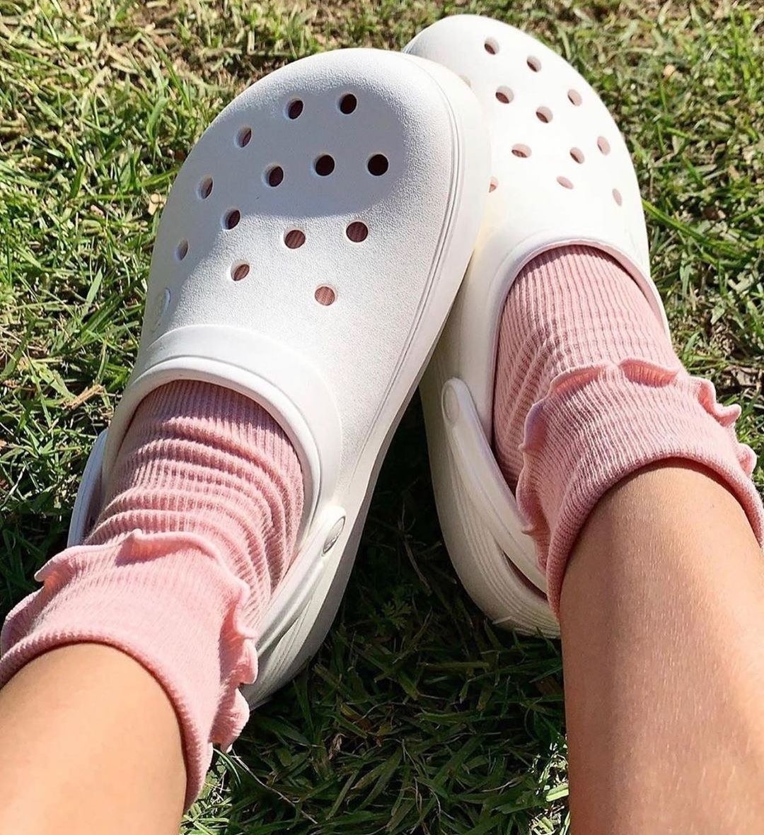 A person wearing Crocs with socks