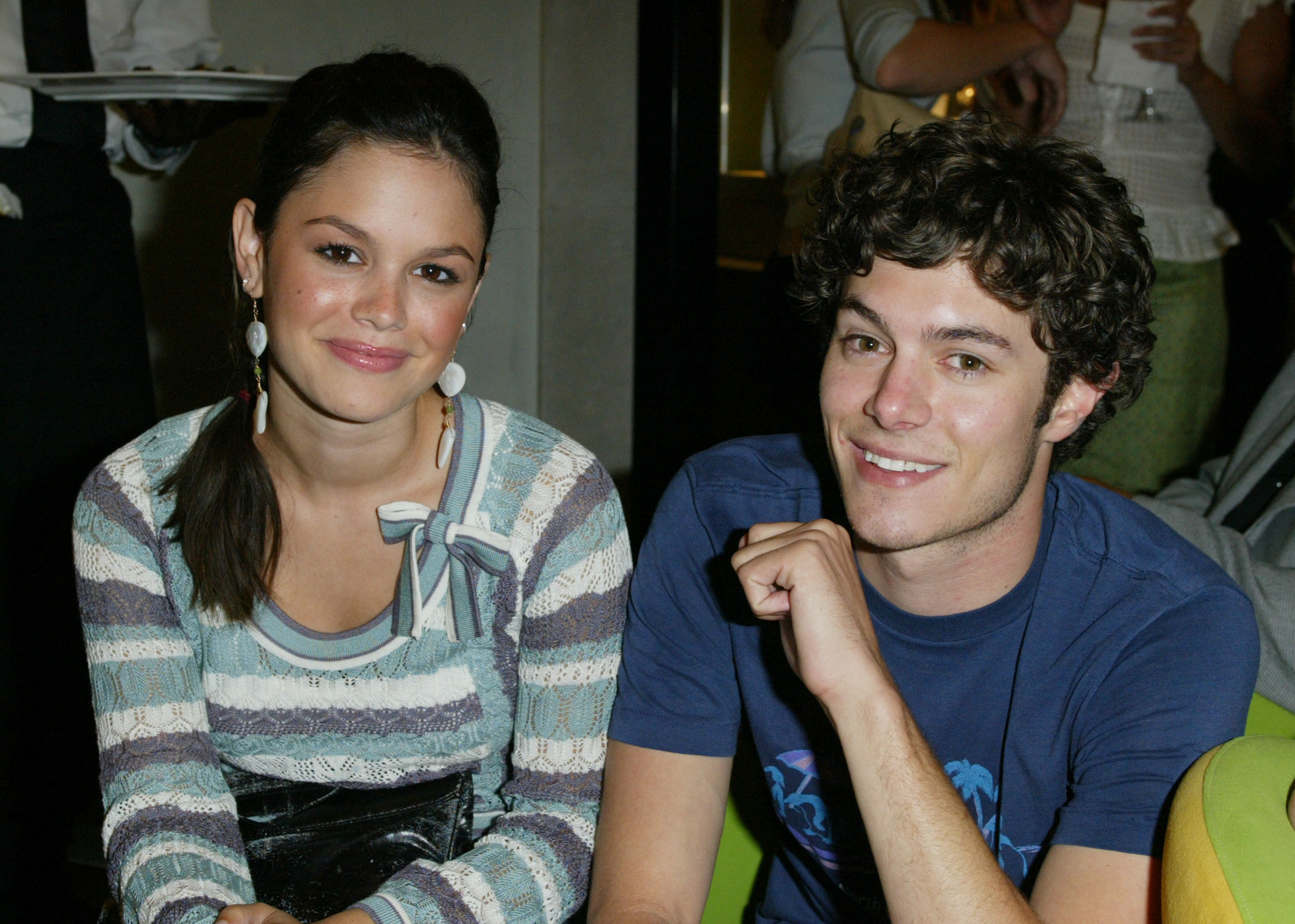 Rachel and Adam smile while sitting next to each other