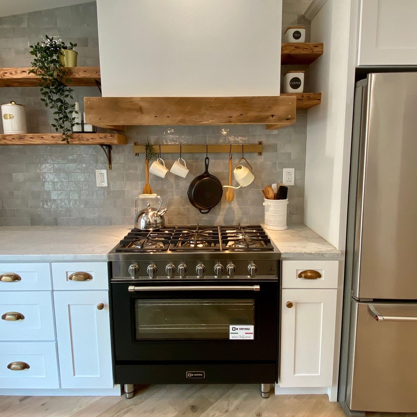 brass rod hung above stove with hooks for hanging kitchen essentials