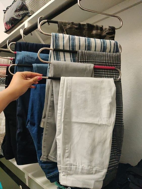 reviewer&#x27;s picture of the S-shaped hangers storing pants