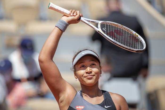 Naomi waving to the crowd after winning a tennis match