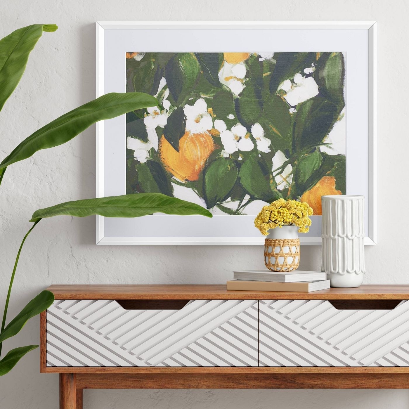 a painting with oranges, white flowers, and greenery over a table