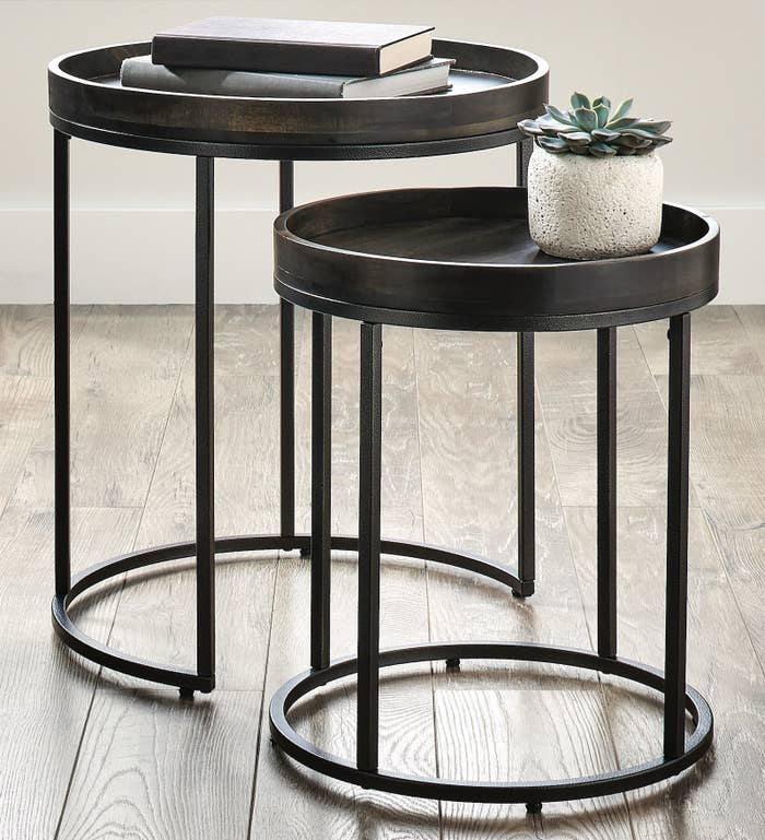 The black, round nesting tables in a living room