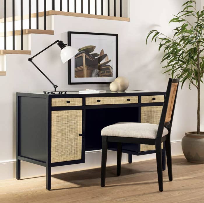 the desk, which is black with light contrast raffia panels