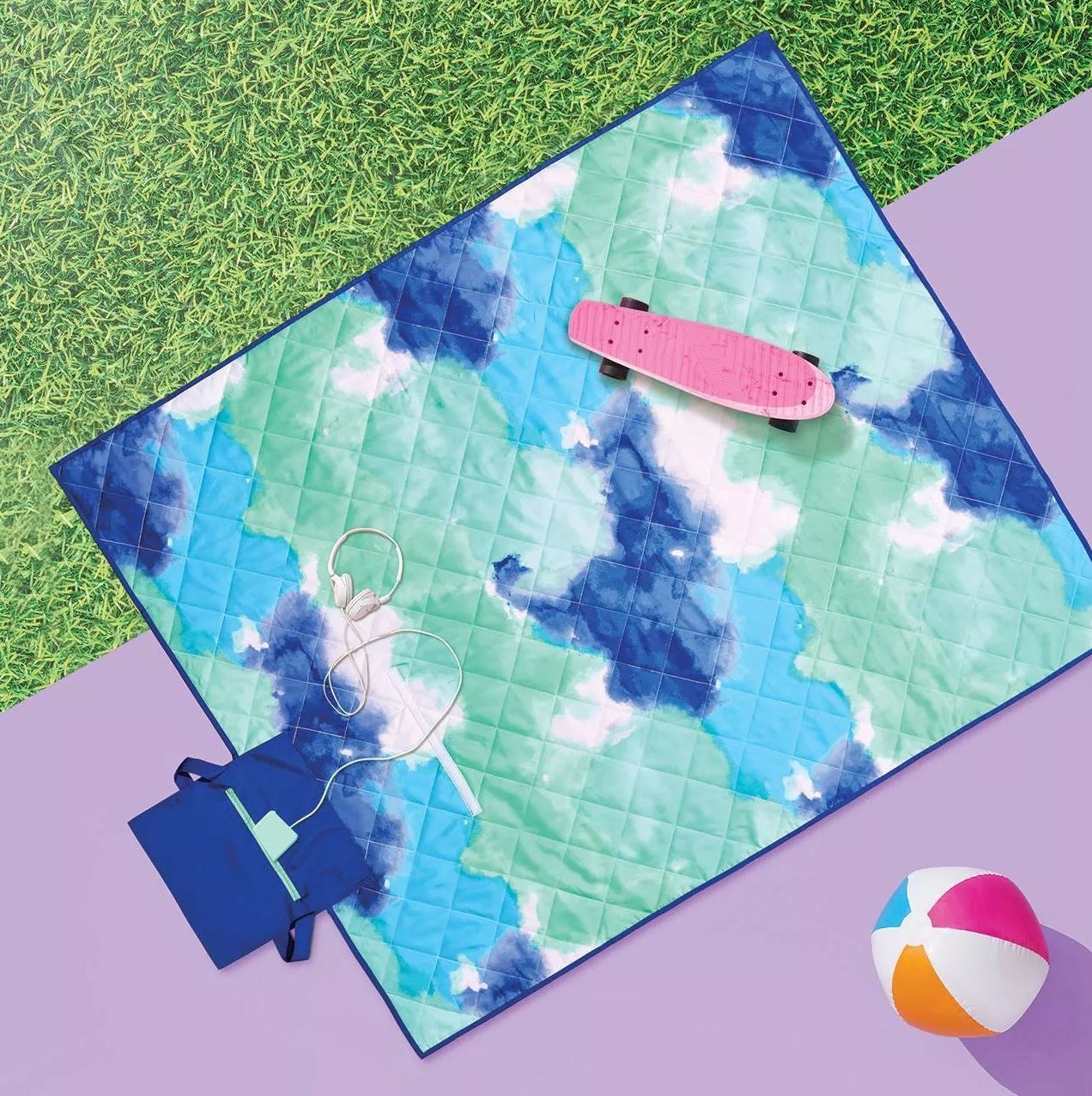 The quilted blanket with a separate compartment for your belongings on the grass