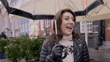A person laughing while holding an umbrella