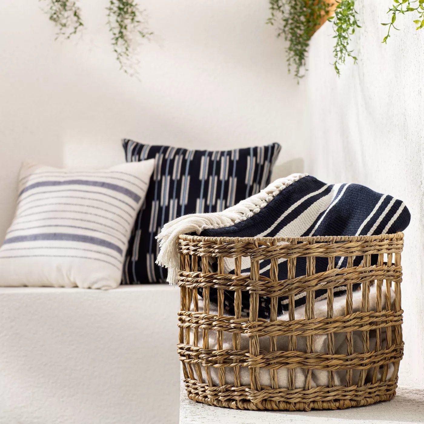 The rattan storage basket outside holding blankets