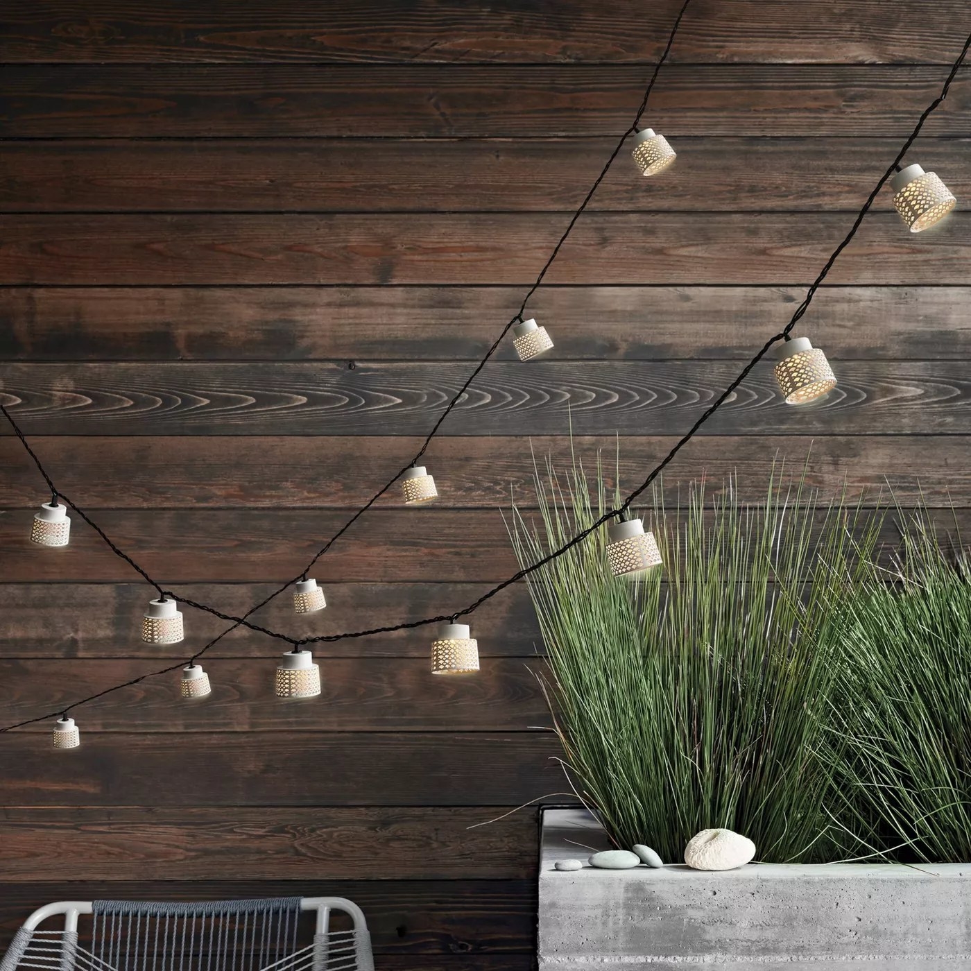 The lantern string lights with punched details hanging in a backyard
