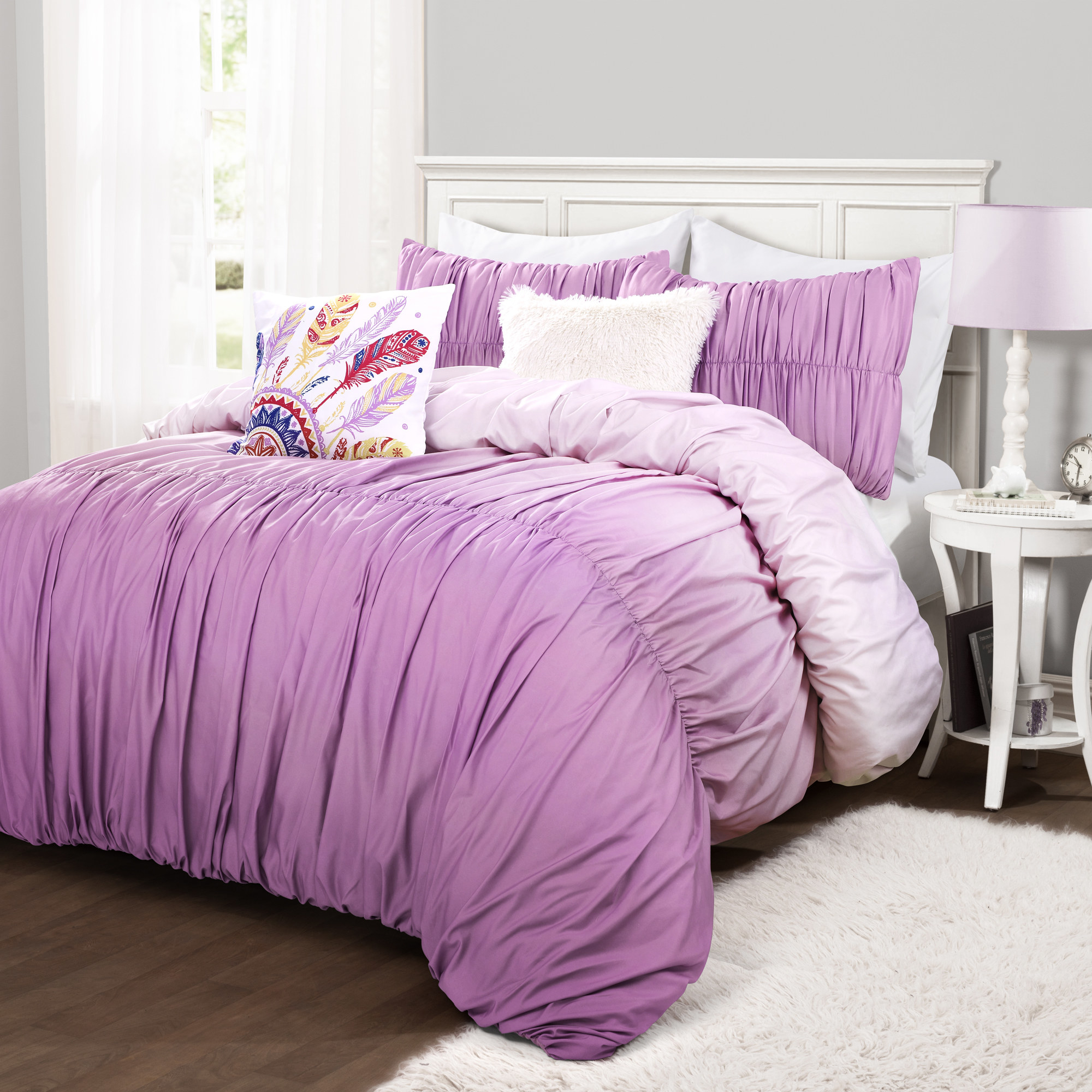 The purple/white gradient-colored comforter set on a bed