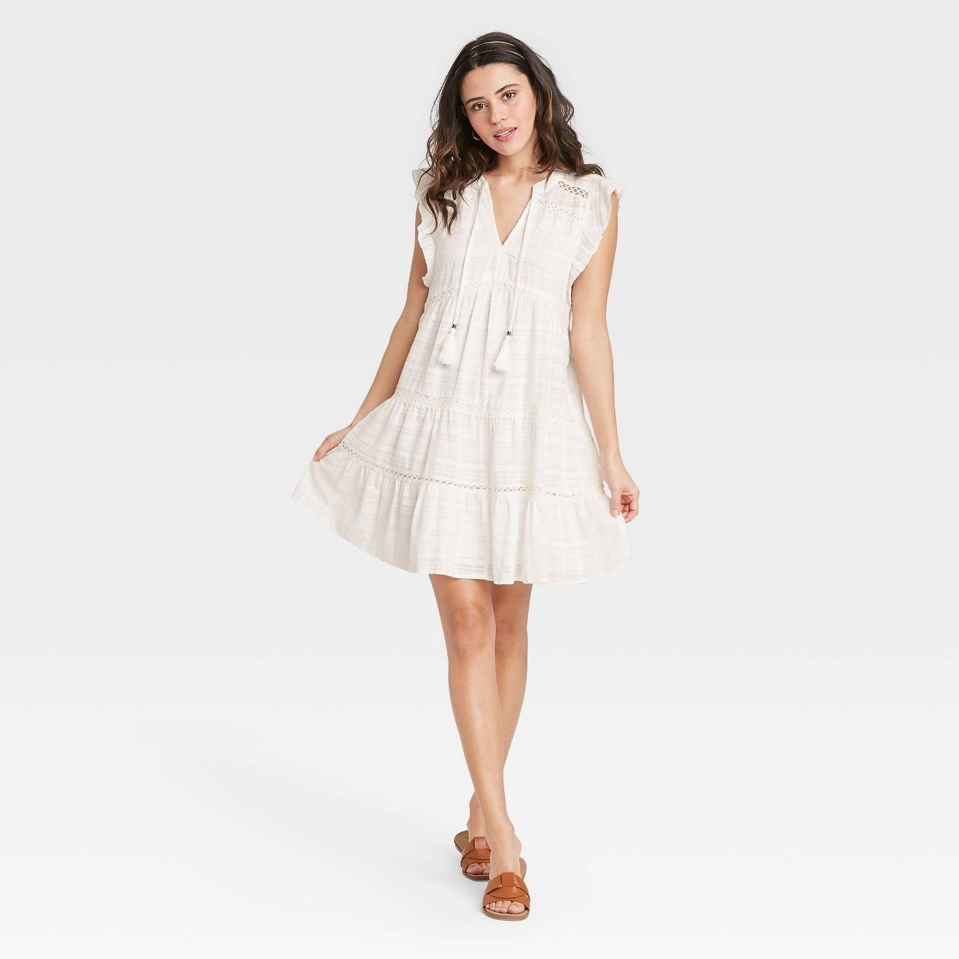 A model wearing a white mini ruffle dress