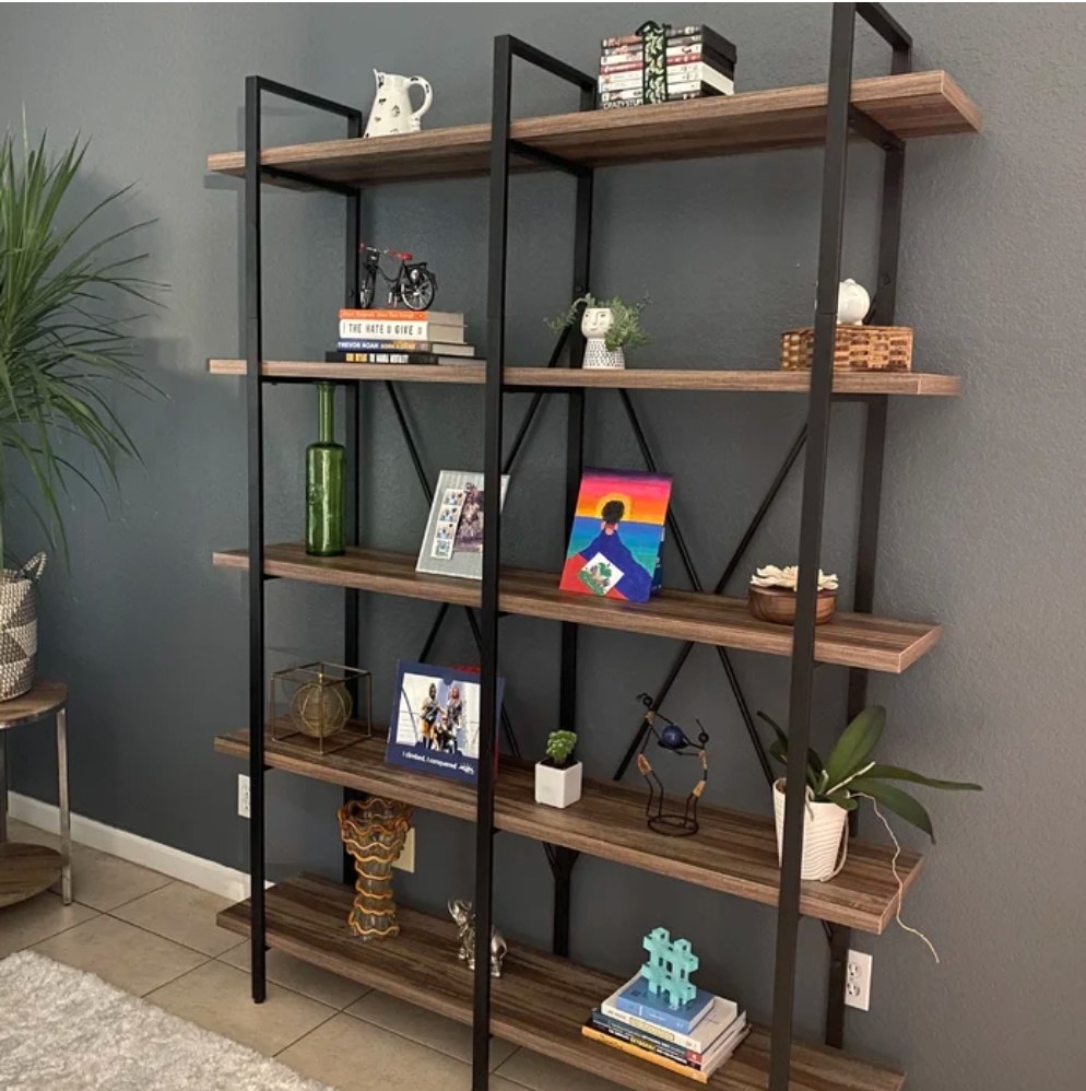 A reviewer&#x27;s wood and iron bookcase with 10 shelves filled with decorative items