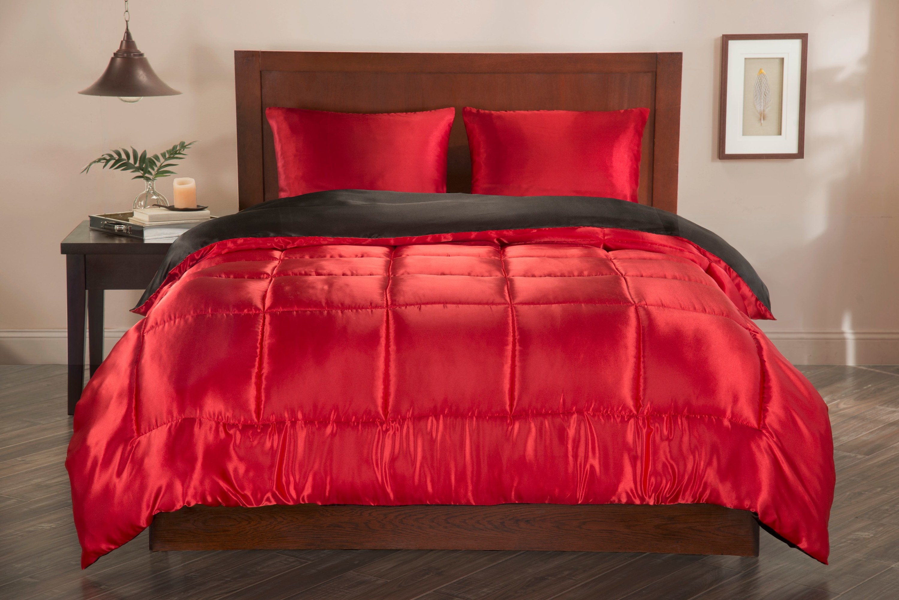 The red and black bedding on a bed. It&#x27;s shiny and awesome.