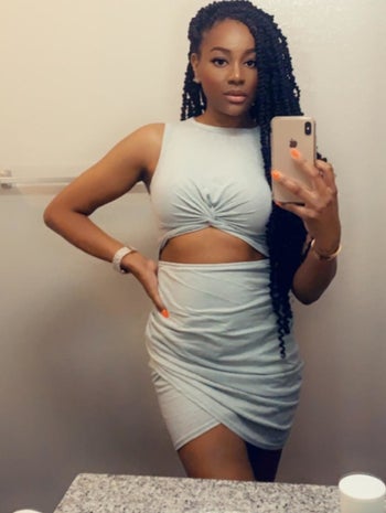 reviewer wearing the grey midi dress with high neckline and cutout at upper stomach 