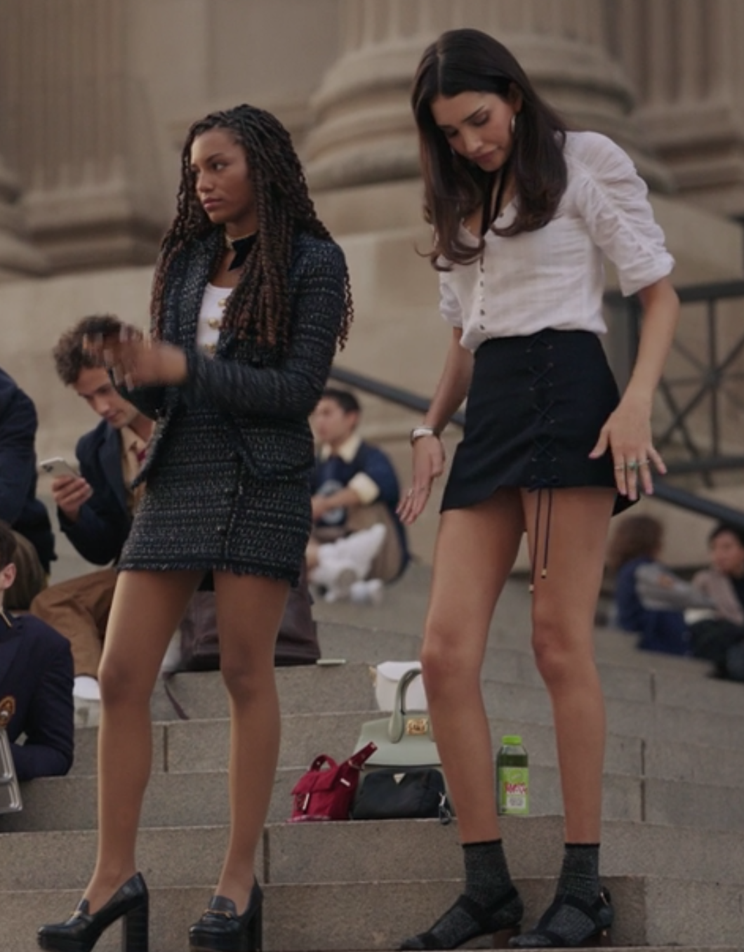 Monet wears a tweed blazer and skirt set and Luna wears a mini skirt with a button up top tucked into it