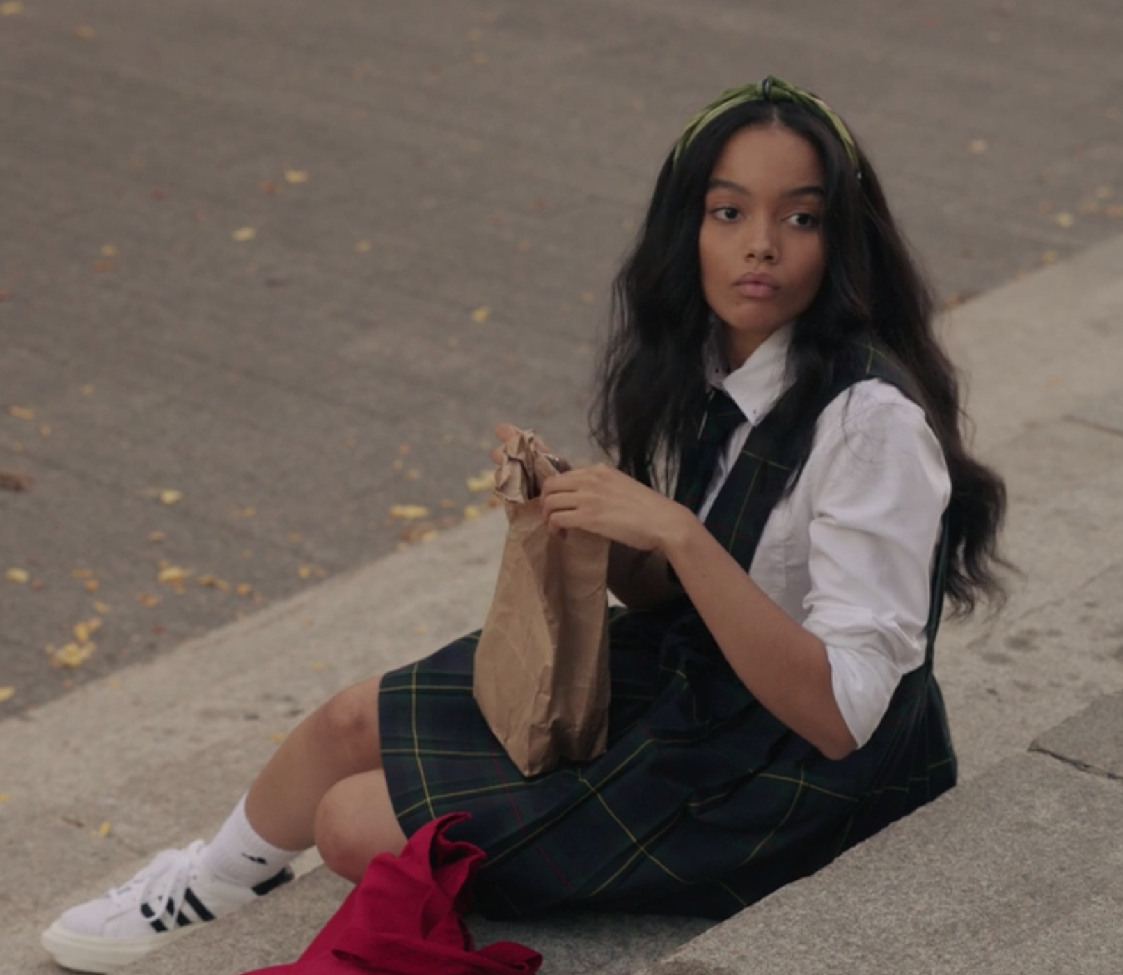 Zoya wears a striped uniform jumper skirt over a long sleeve shirt