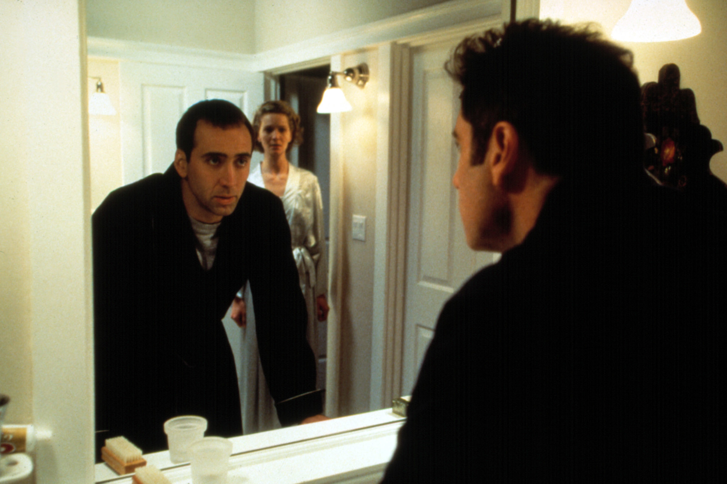 Nicholas Cage looking into a mirror in a scene from Face/Off