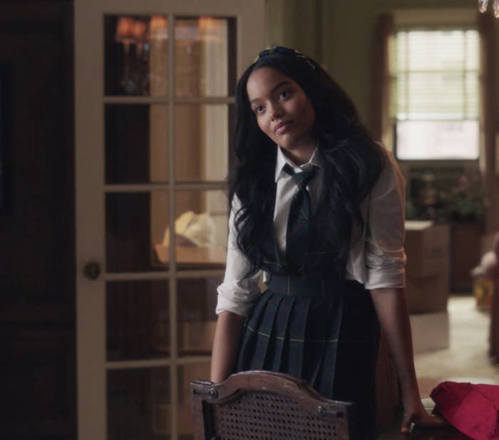 Whitney Peak in a plaid school uniform as Zoya Lott