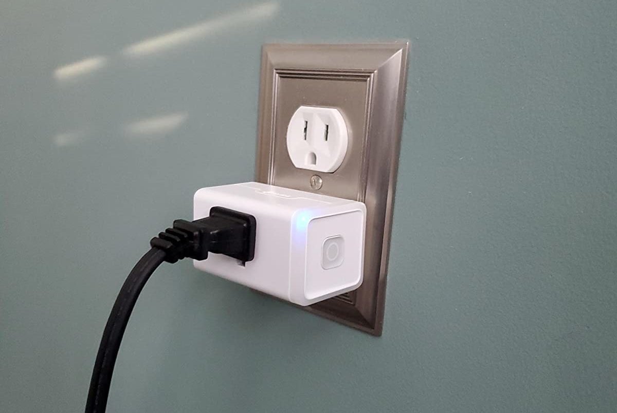 a reviewer photo of a smart outlet plugged into a standard electrical wall outlet