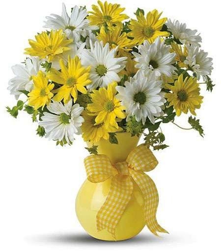 bouquet of white and yellow daisies in a yellow vase