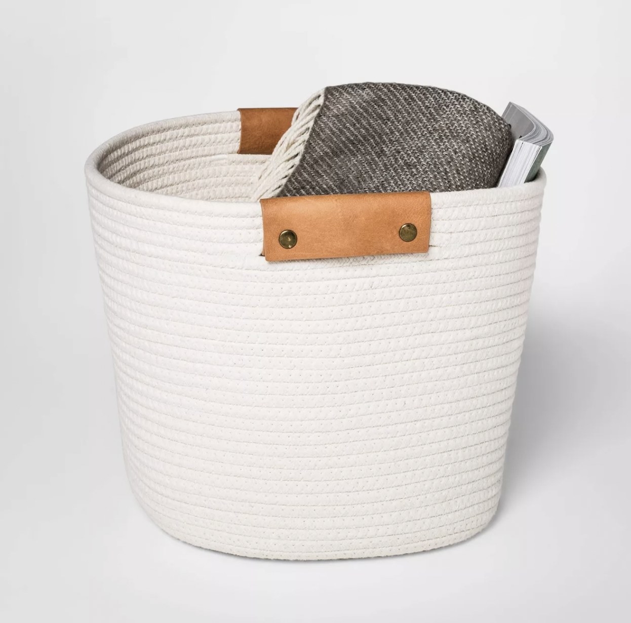 An ivory woven basket with tan leather handles