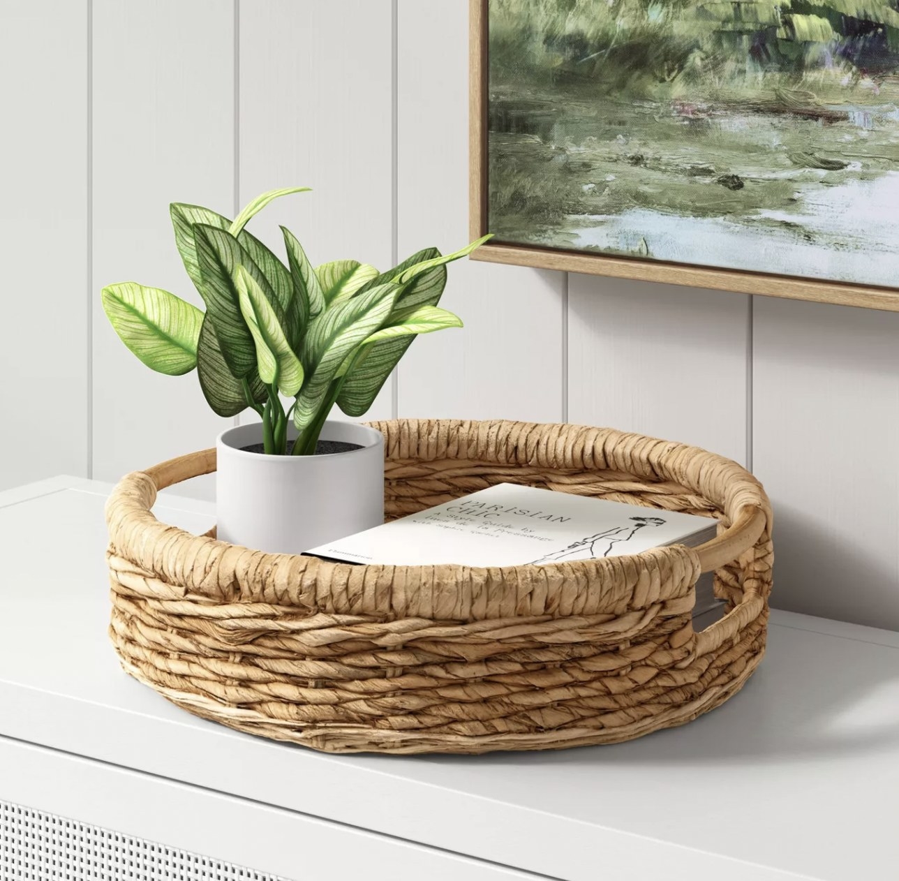 a wicker tray holding a book and a potted plant