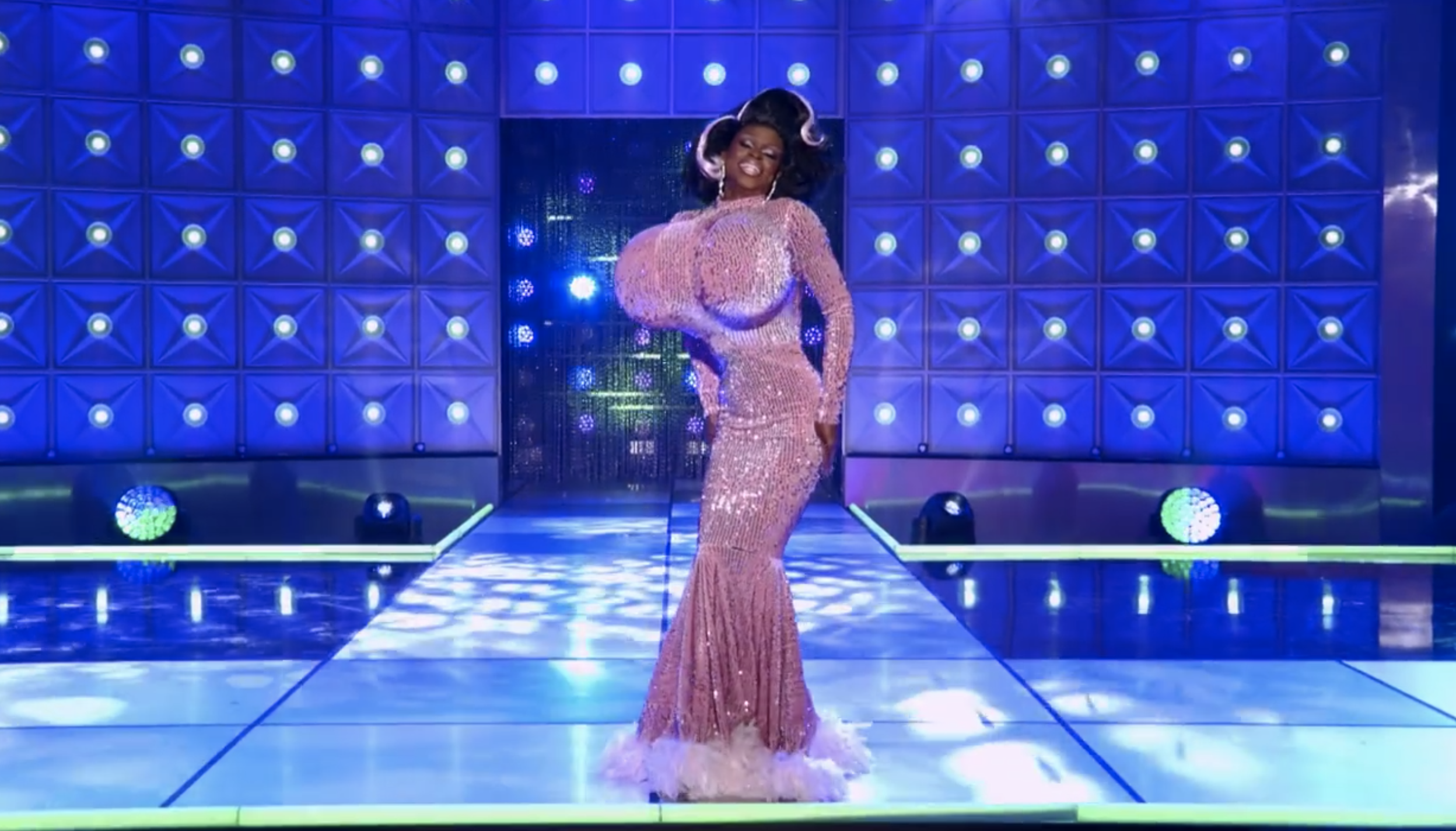 Symone on stage in a sequined and feathered gown