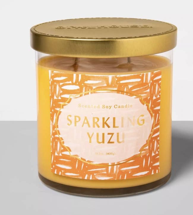 a yellow candle that reads sparkling yuzu
