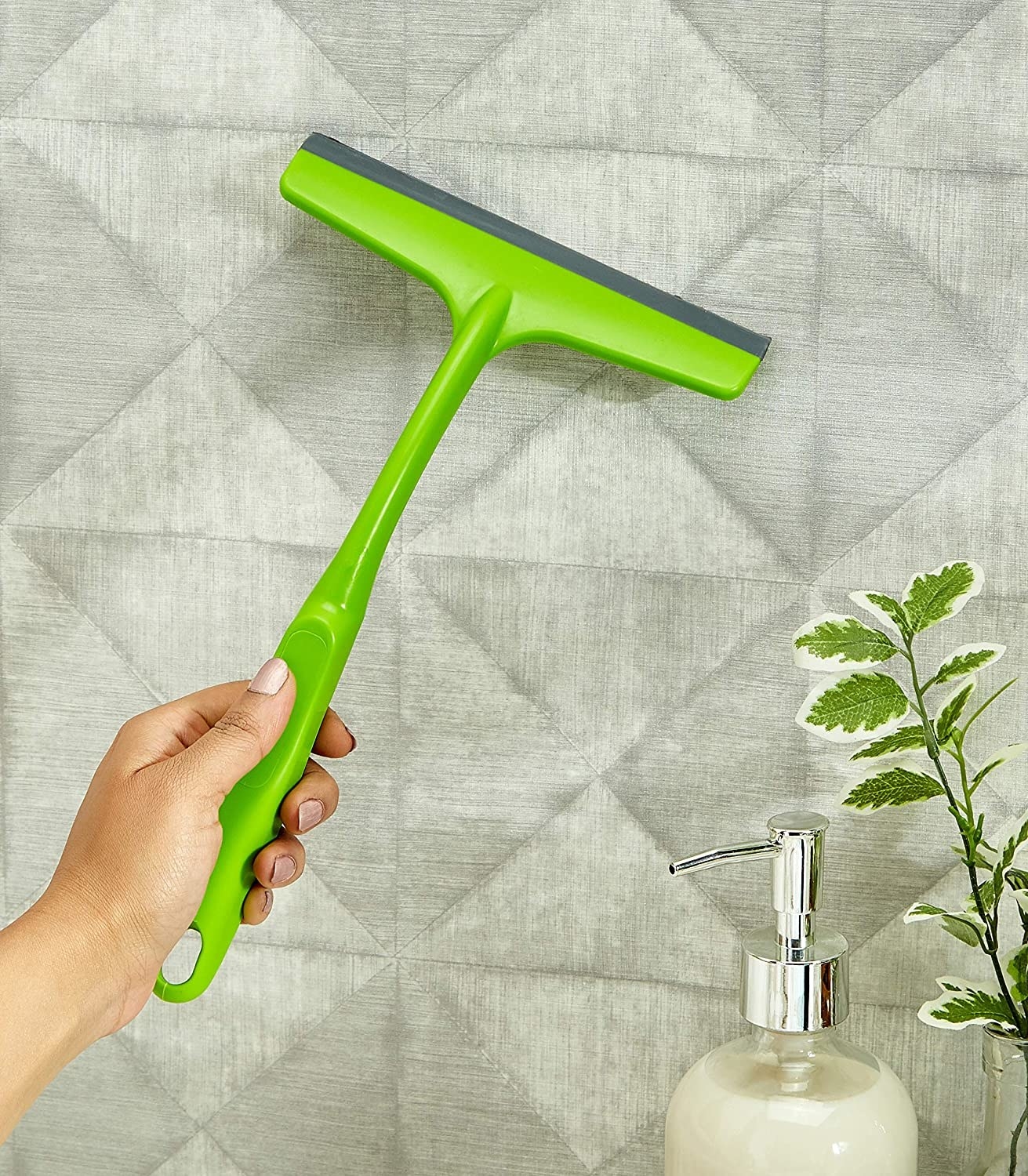 A person using the squeegee to clean a wall