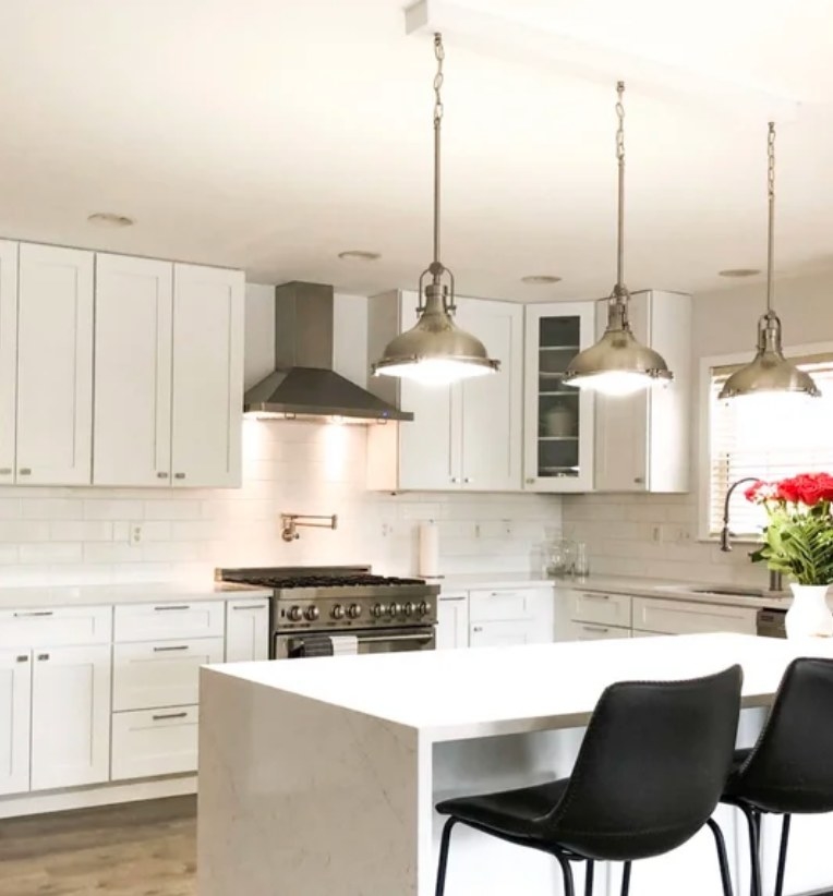 A reviewer&#x27;s modern, dome pendant light in brushed nickel hanging in a kitchen