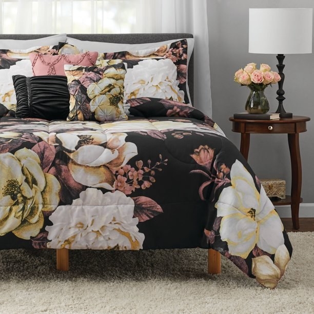 The floral bedspread on and pillows on a bed