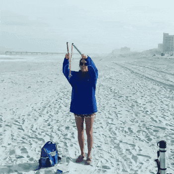 Reviewer using the bubble wand to blow giant bubbles on the beach