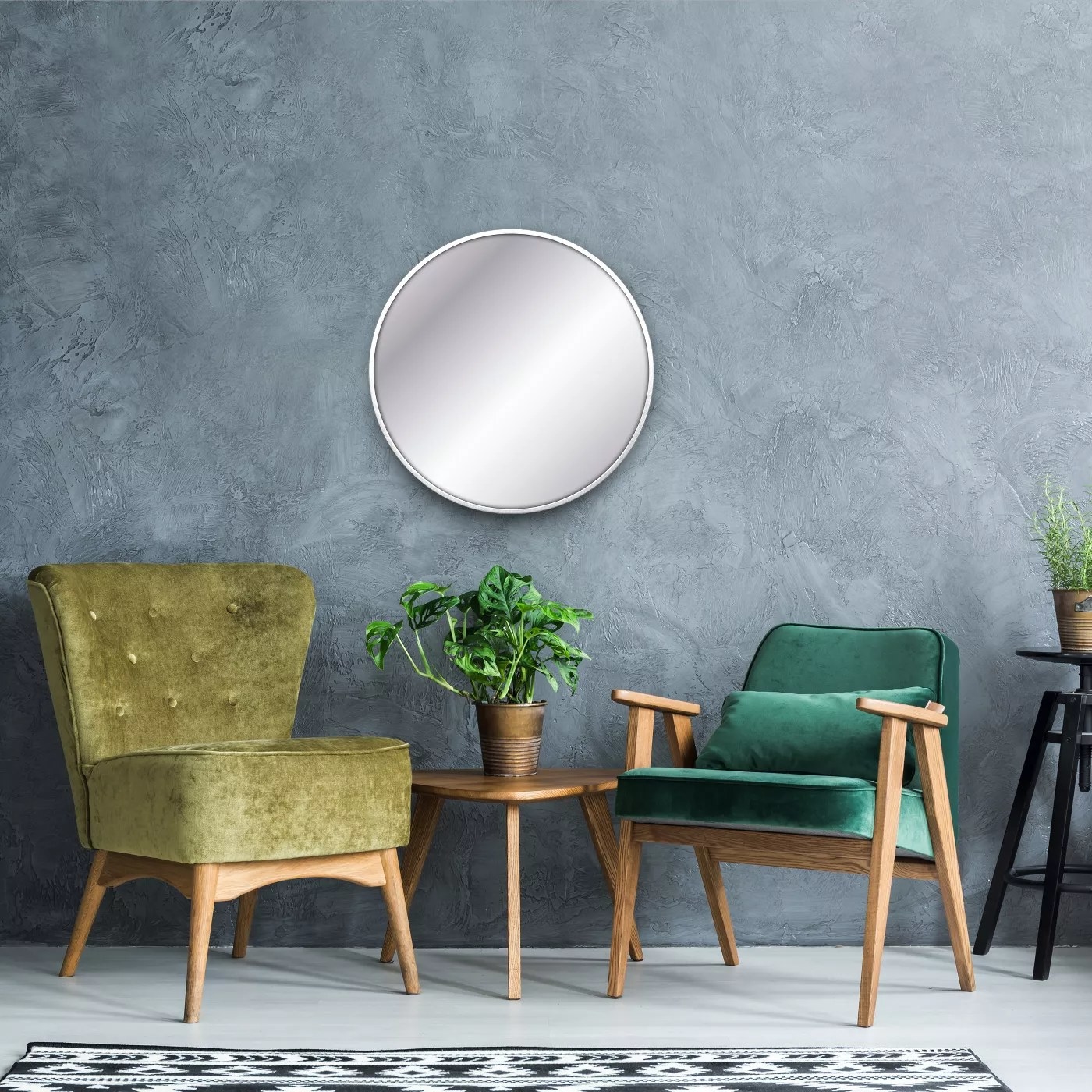 The round mirror with a metal frame hanging on a wall in a living room