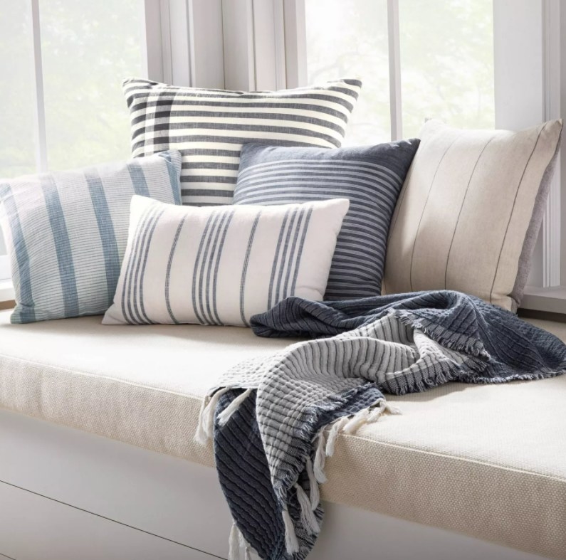 the blue and white striped pillow on a couch with other pillows