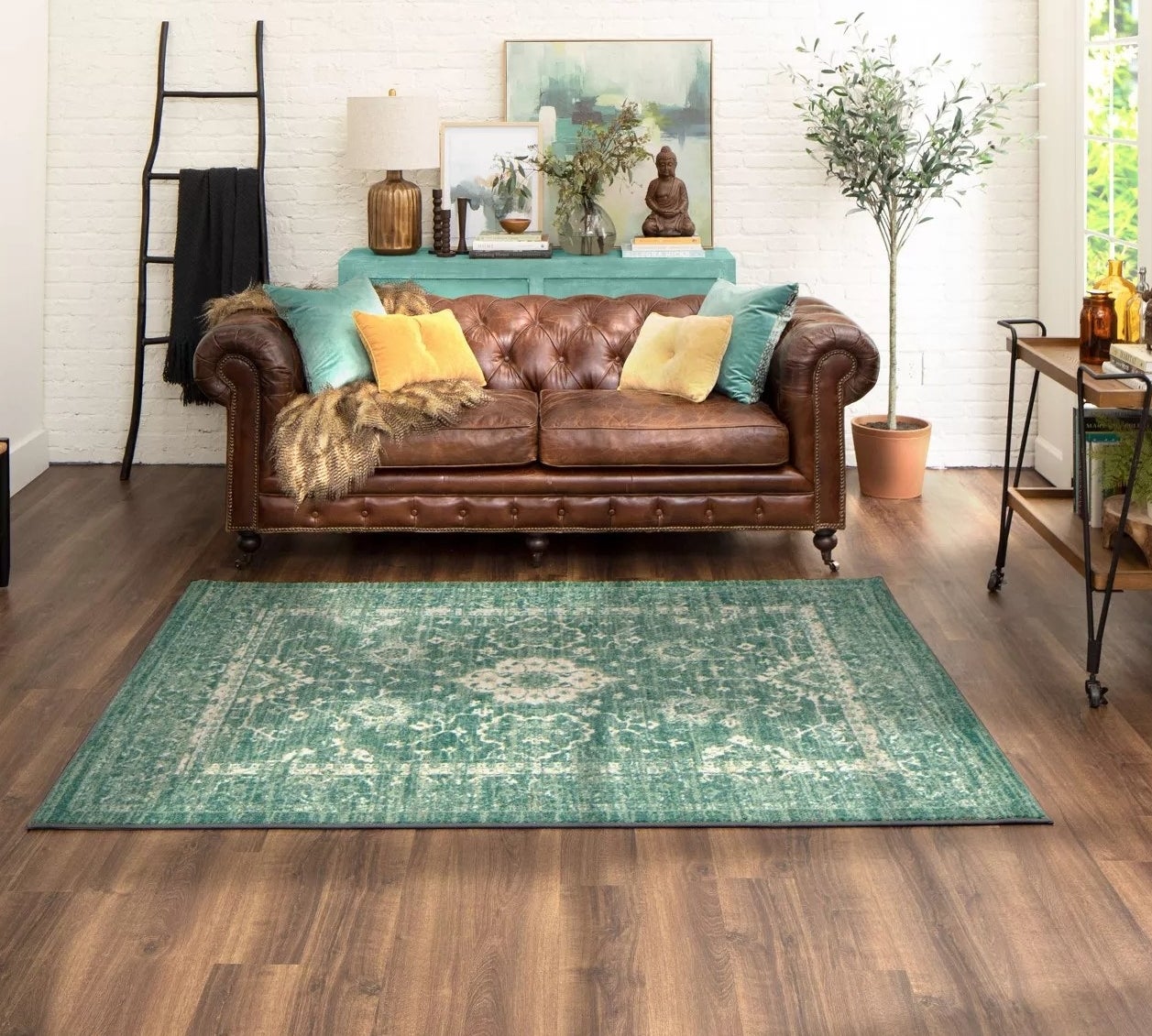 The green rug with a light floral pattern and distressed details in a living room