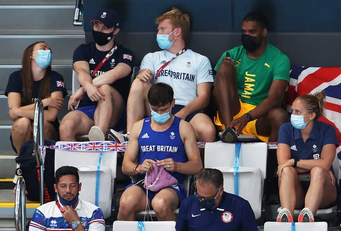 Tom Daley of Great Britain knits as he watches the Women&#x27;s 3m Springboard Final