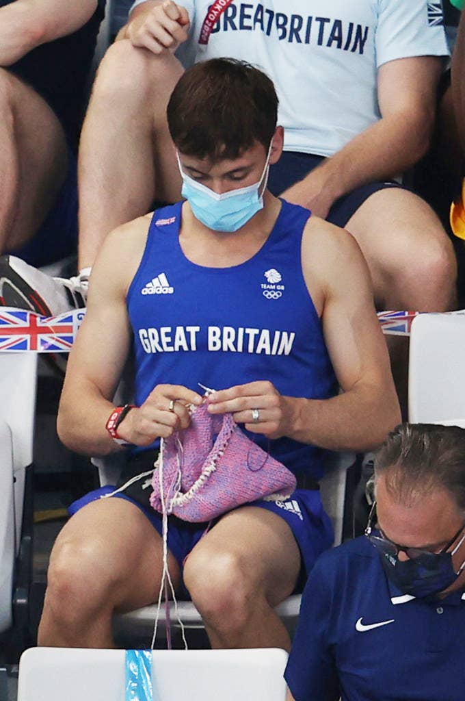 Tom Daley of Great Britain knits as he watches the Women&#x27;s 3m Springboard Final