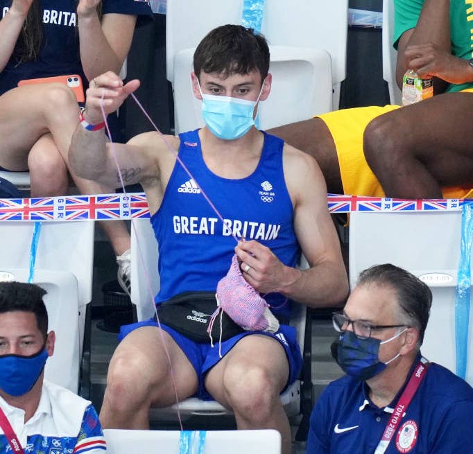 Tom Daley of Great Britain knits as he watches the Women&#x27;s 3m Springboard Final