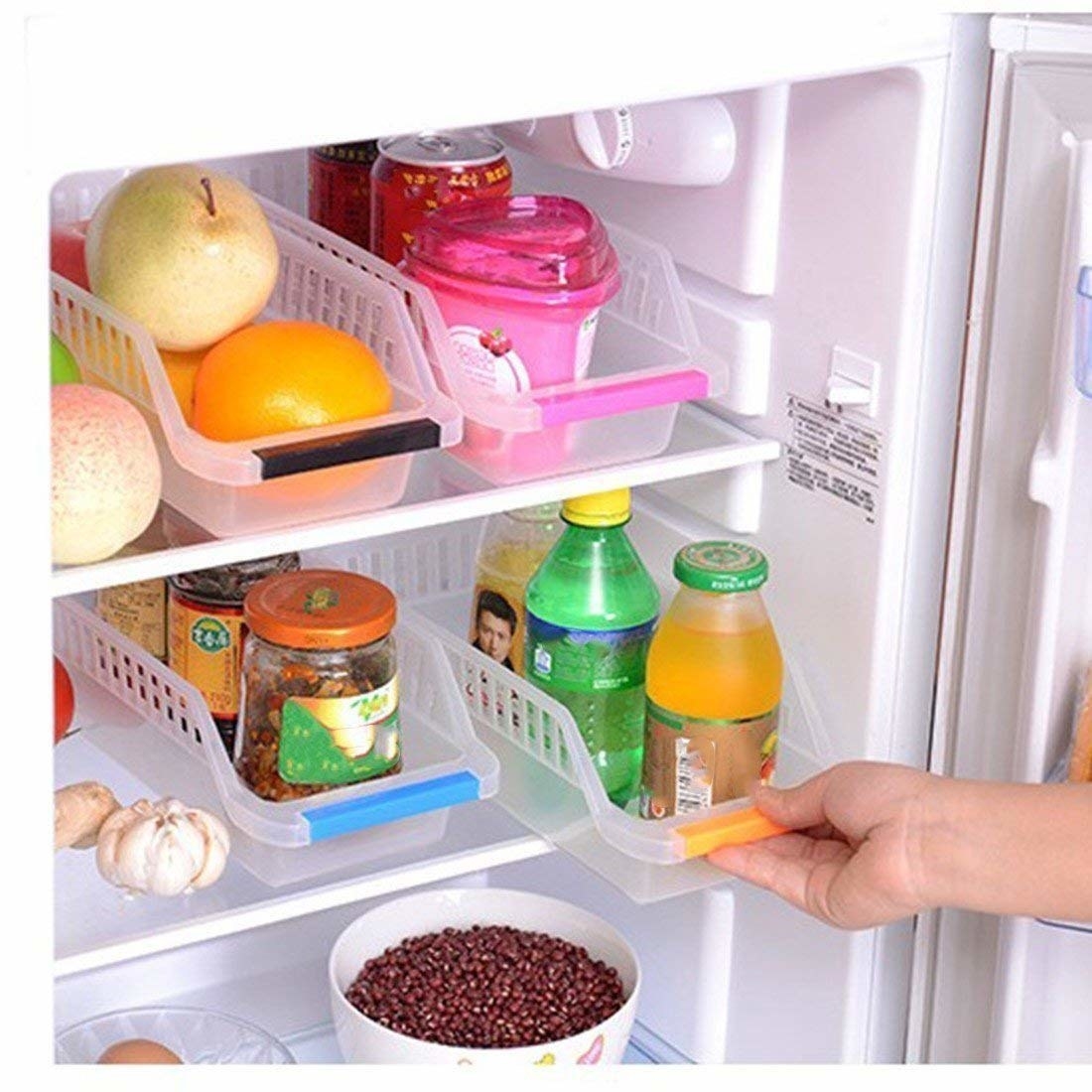 A set of fridge bins with food items in them and a hand pulling them out